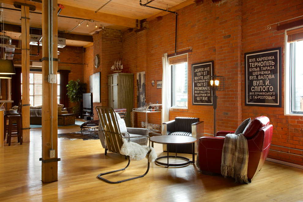Example of a huge urban open concept medium tone wood floor living room design in Edmonton with orange walls