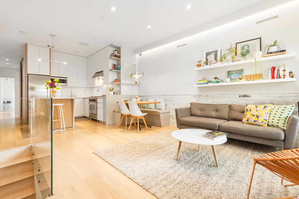 Small modern formal open plan living room in New York with white walls, light hardwood flooring, no fireplace, no tv and beige floors.
