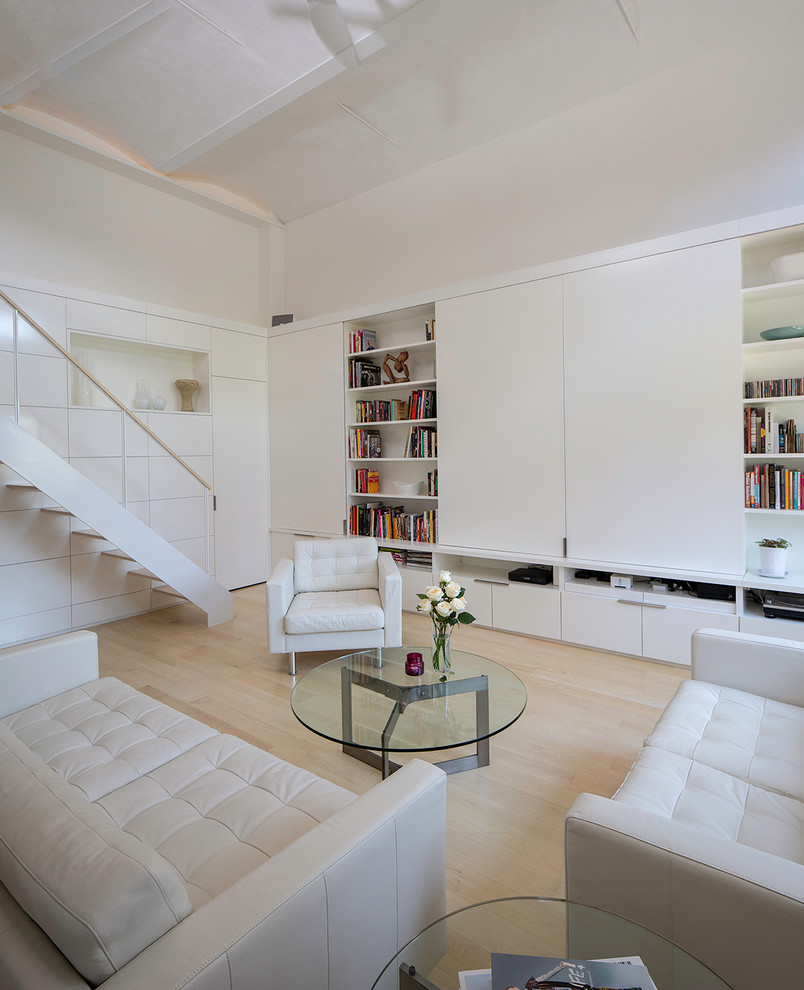 Réalisation d'un salon design avec un mur blanc, parquet clair, un téléviseur dissimulé et un sol beige.