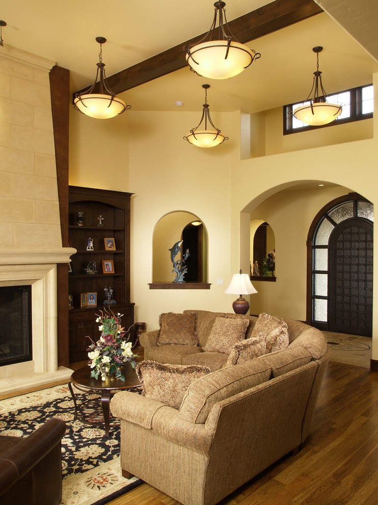 Example of a large classic formal and open concept medium tone wood floor living room design in Denver with a standard fireplace, a stone fireplace, yellow walls and no tv
