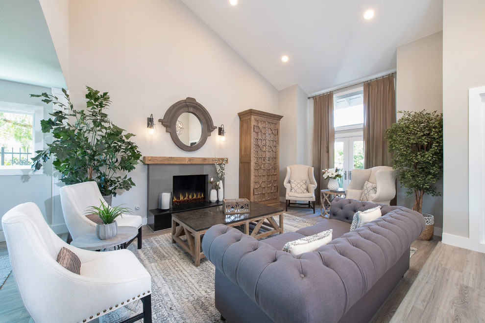 Photo of a traditional open plan living room in Orange County with grey walls, a standard fireplace and brown floors.
