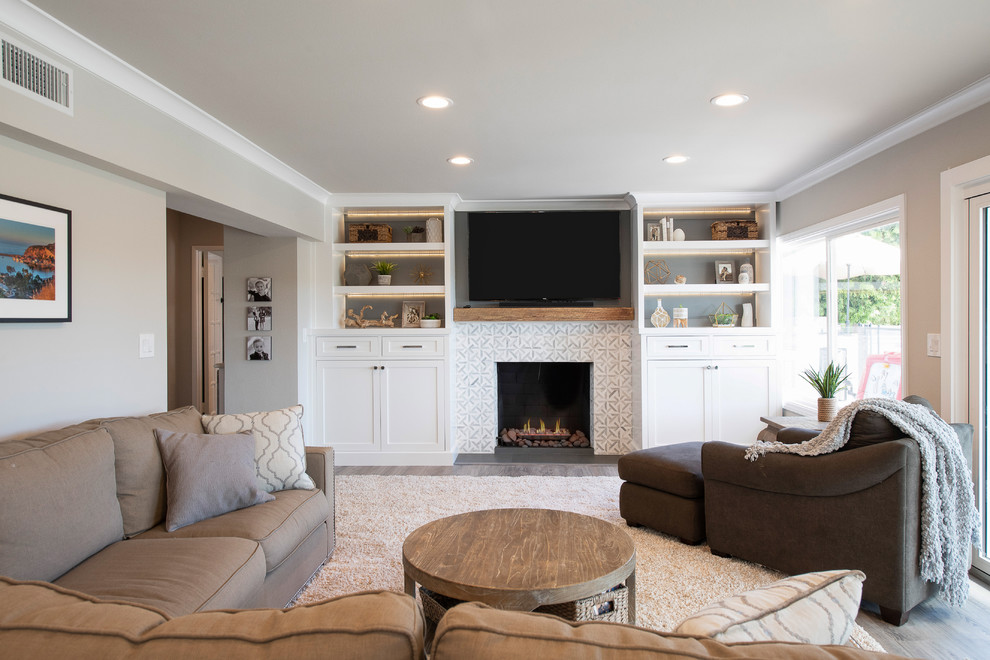 Abgetrenntes Klassisches Wohnzimmer mit grauer Wandfarbe, dunklem Holzboden, Kamin, gefliester Kaminumrandung und braunem Boden in Orange County