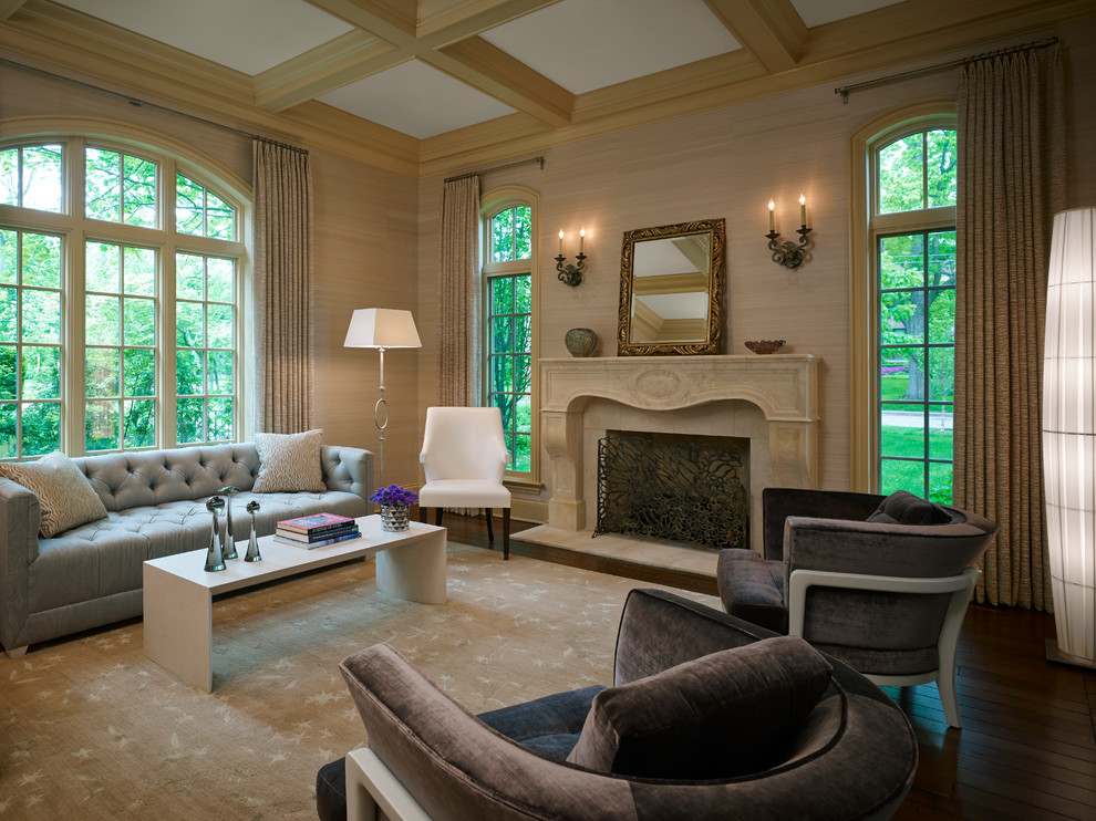 Exemple d'un grand salon chic avec un mur beige, parquet foncé, une cheminée standard et un manteau de cheminée en pierre.