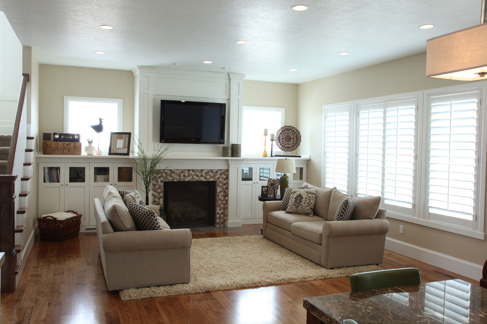 Medium sized classic open plan living room in Salt Lake City with beige walls, medium hardwood flooring, a standard fireplace, a tiled fireplace surround and a wall mounted tv.