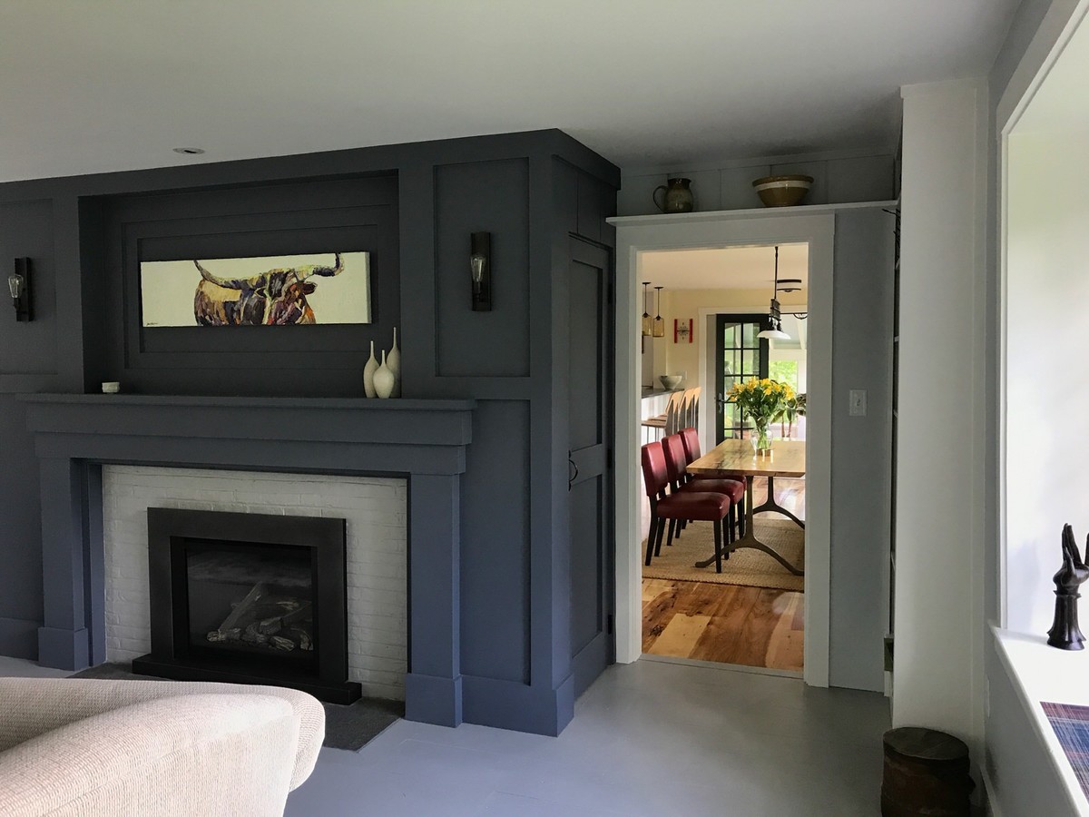 Mittelgroßes, Abgetrenntes Klassisches Wohnzimmer mit grauer Wandfarbe, gebeiztem Holzboden, Kamin, Kaminumrandung aus Holz und grauem Boden in Boston