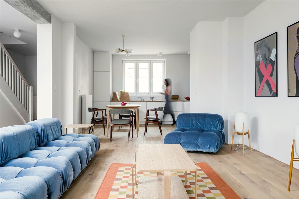 Immagine di un soggiorno moderno di medie dimensioni e aperto con sala formale, pareti bianche, parquet chiaro, nessun camino, nessuna TV e pavimento marrone
