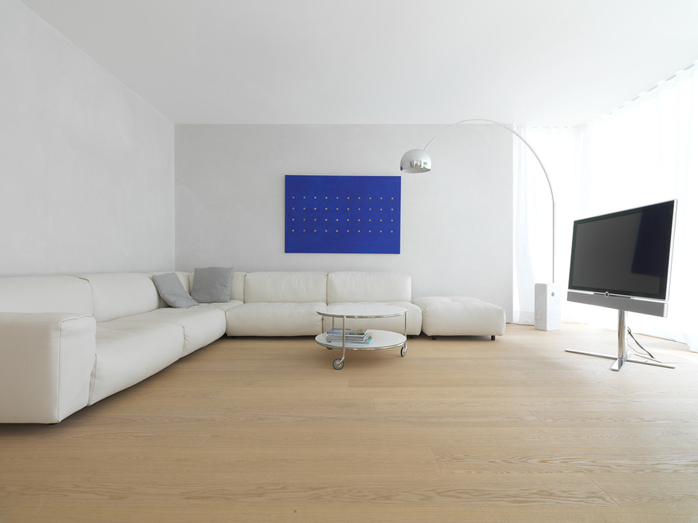 Mittelgroßes Modernes Wohnzimmer ohne Kamin mit weißer Wandfarbe, braunem Holzboden und freistehendem TV in Sonstige