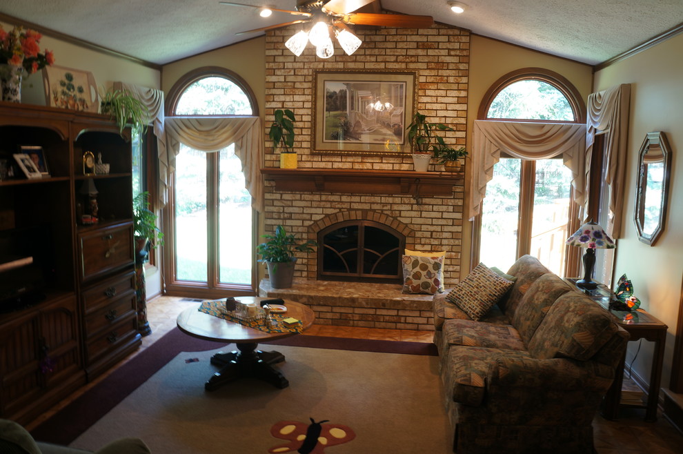 Idée de décoration pour un salon tradition fermé avec un mur beige, un sol en bois brun, une cheminée standard, un manteau de cheminée en brique et un téléviseur encastré.
