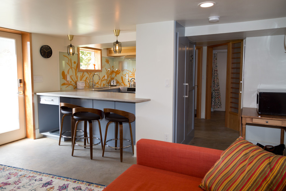 Стильный дизайн: маленькая открытая гостиная комната в стиле модернизм с белыми стенами, бетонным полом, отдельно стоящим телевизором и разноцветным полом без камина для на участке и в саду - последний тренд