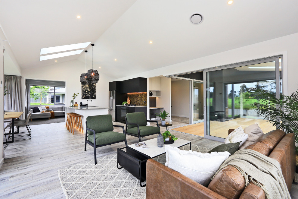 Photo of a modern open plan living room in Napier-Hastings with white walls, light hardwood flooring, no fireplace, no tv, grey floors, a vaulted ceiling and panelled walls.