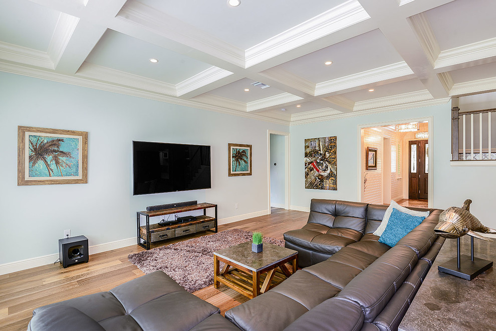 Стильный дизайн: большая открытая гостиная комната в стиле неоклассика (современная классика) с синими стенами, светлым паркетным полом и телевизором на стене - последний тренд