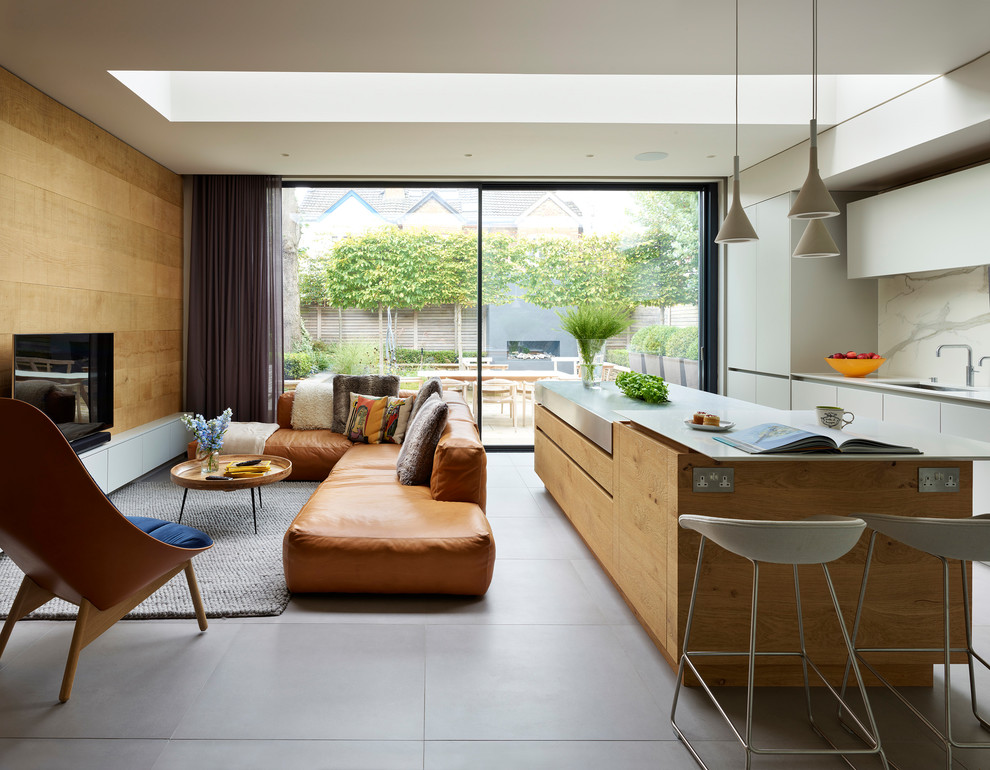 Photo of a contemporary open plan living room in London with brown walls, a freestanding tv and grey floors.