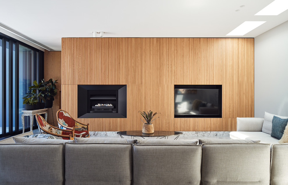 Exempel på ett stort modernt allrum med öppen planlösning, med kalkstensgolv, en standard öppen spis, en spiselkrans i metall, en inbyggd mediavägg, grått golv och grå väggar