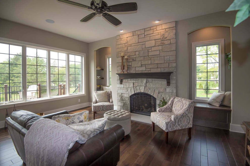 Photo of a medium sized classic formal enclosed living room in Milwaukee with beige walls, dark hardwood flooring, a standard fireplace, a stone fireplace surround, brown floors and no tv.