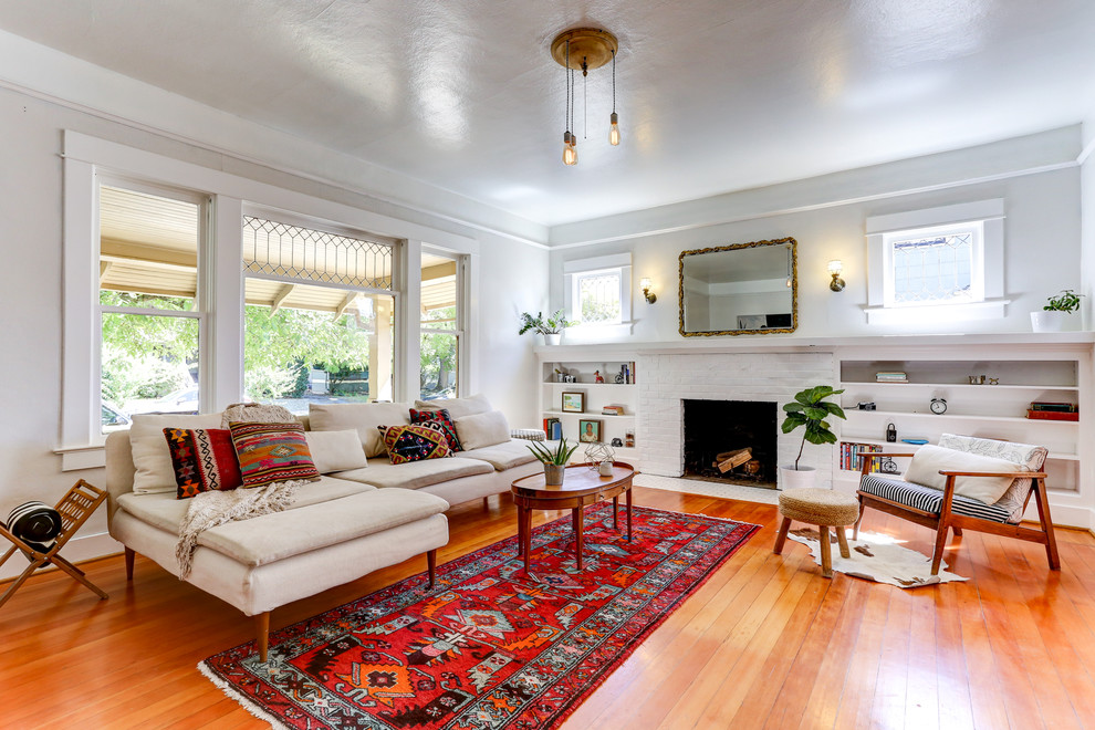 Inspiration for a mid-sized eclectic formal and enclosed light wood floor living room remodel in Portland with white walls, a standard fireplace, a brick fireplace and a tv stand