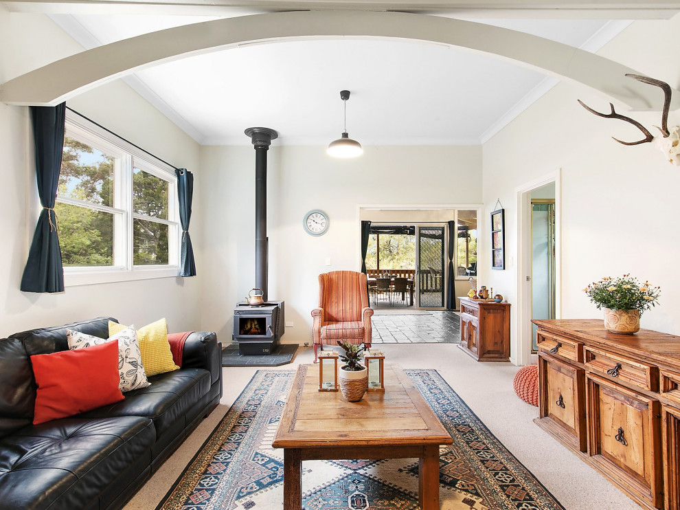Inspiration för ett vintage separat vardagsrum, med beige väggar, heltäckningsmatta, en öppen vedspis och beiget golv