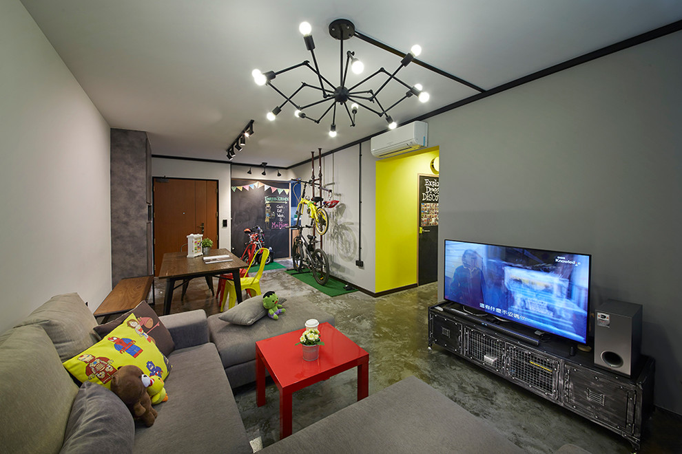 Modelo de salón con barra de bar tipo loft bohemio de tamaño medio con paredes grises, suelo de cemento y televisor independiente