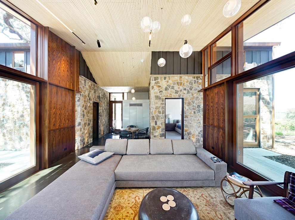 На фото: открытая гостиная комната в стиле кантри с бетонным полом