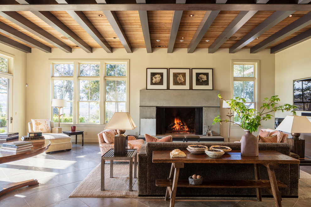Inspiration for a mediterranean brown floor living room remodel in San Francisco with beige walls, a standard fireplace, a concrete fireplace and a wall-mounted tv
