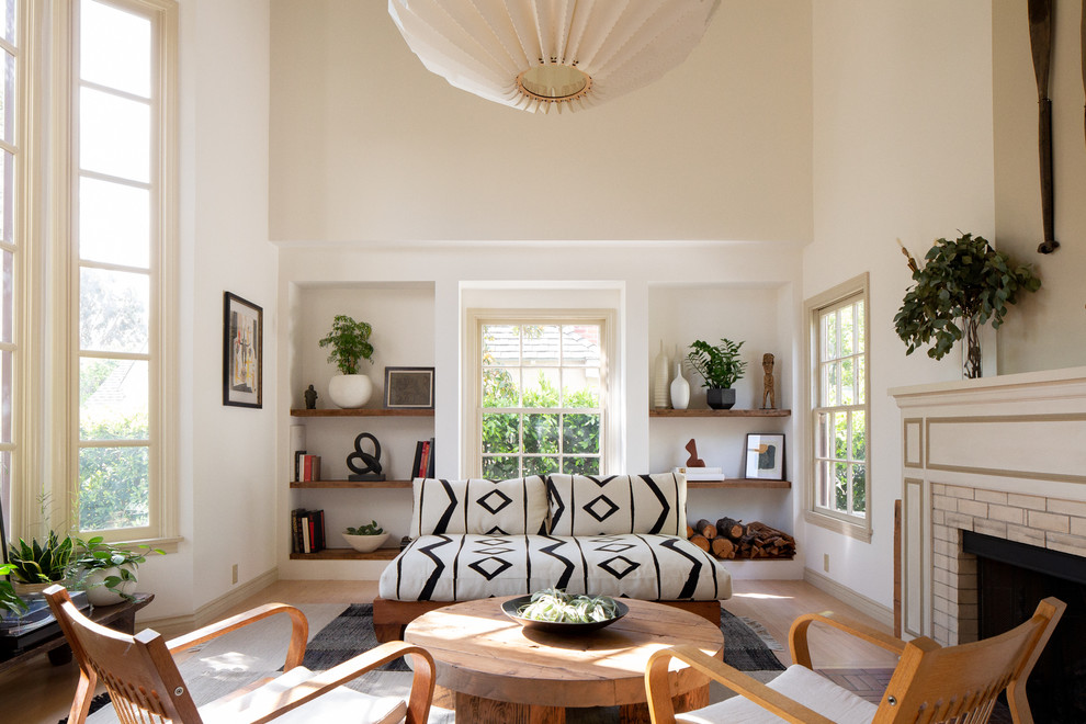 Maritimes Wohnzimmer mit weißer Wandfarbe, hellem Holzboden, Kamin, Kaminumrandung aus Backstein und beigem Boden in Los Angeles