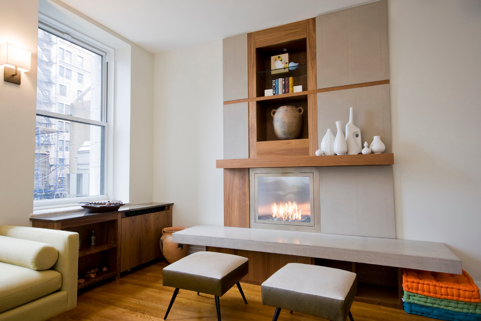 Mittelgroßes Modernes Wohnzimmer mit weißer Wandfarbe, braunem Holzboden, Gaskamin und Kaminumrandung aus Holz in New York