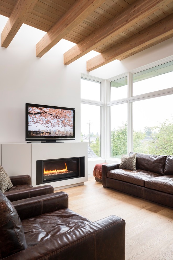 Mittelgroßes, Offenes Modernes Wohnzimmer mit weißer Wandfarbe, braunem Holzboden und Kamin in Vancouver