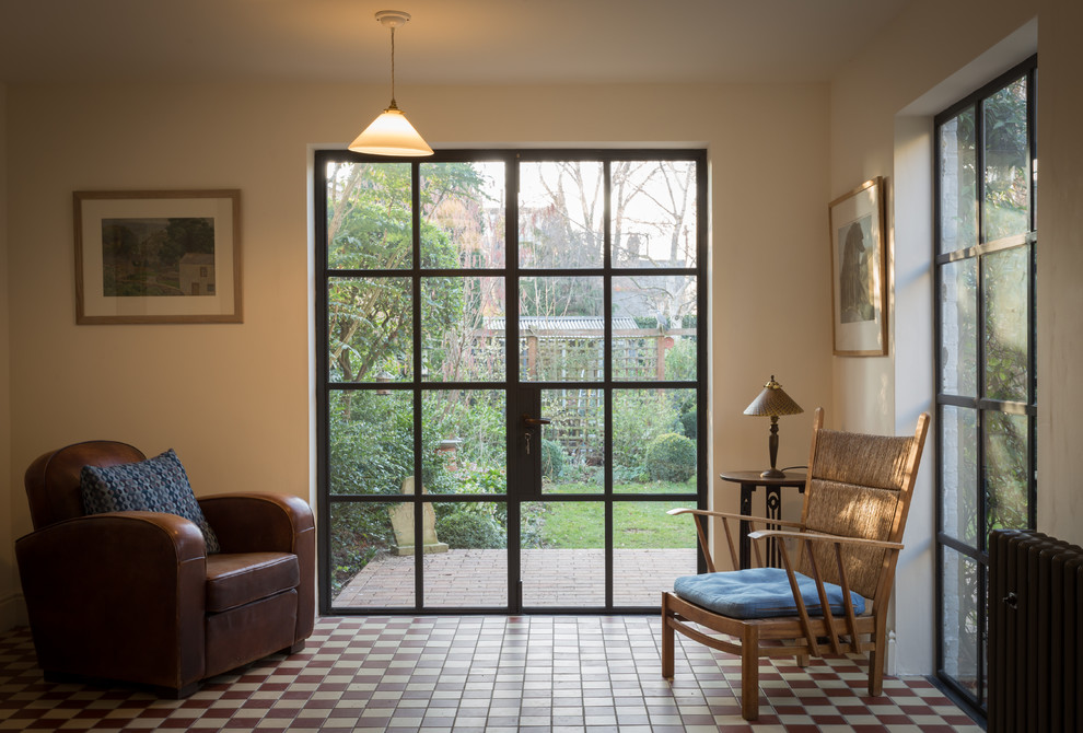 Immagine di un soggiorno minimal di medie dimensioni con libreria, pareti bianche, pavimento con piastrelle in ceramica e pavimento multicolore