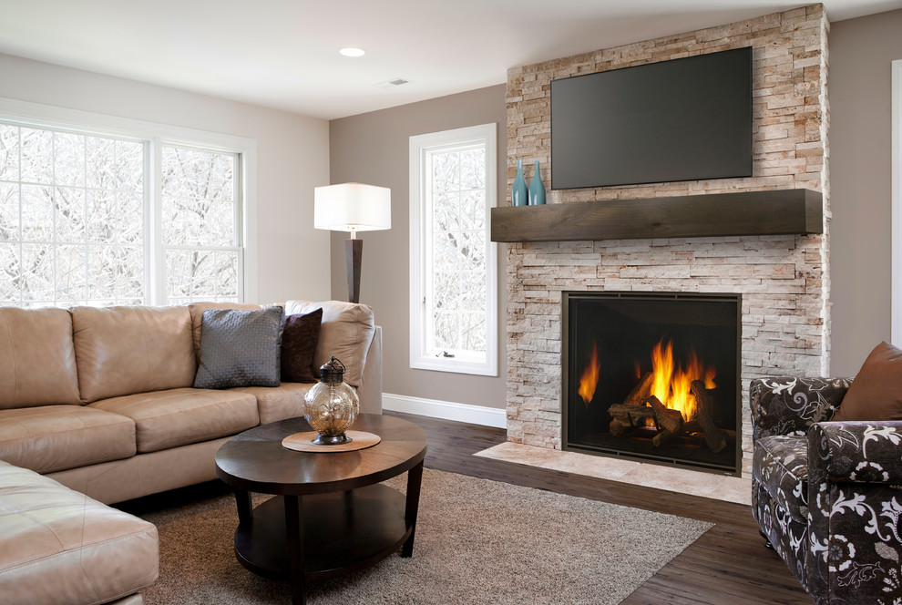 Inspiration for a medium sized classic enclosed living room in Houston with brown walls, dark hardwood flooring, a standard fireplace, a stone fireplace surround, a wall mounted tv, brown floors and feature lighting.