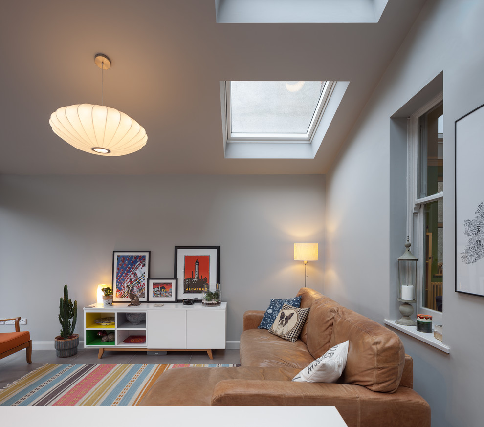 Mittelgroßes, Fernseherloses, Offenes Modernes Wohnzimmer mit Hausbar, grauer Wandfarbe, Keramikboden und grauem Boden in Manchester
