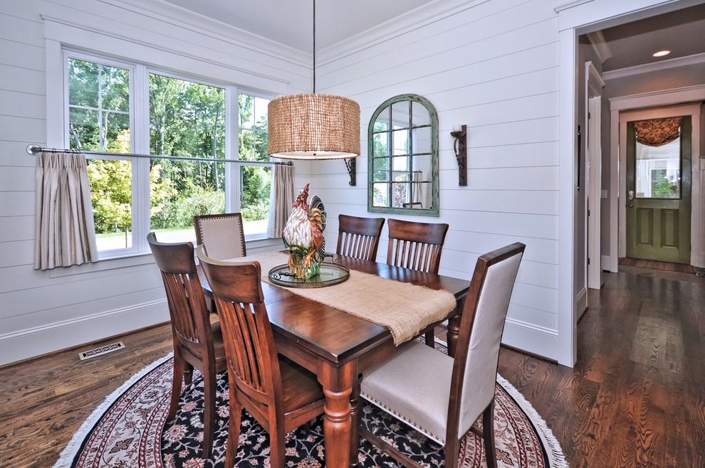 Classic dining room in Charlotte with white walls and dark hardwood flooring.