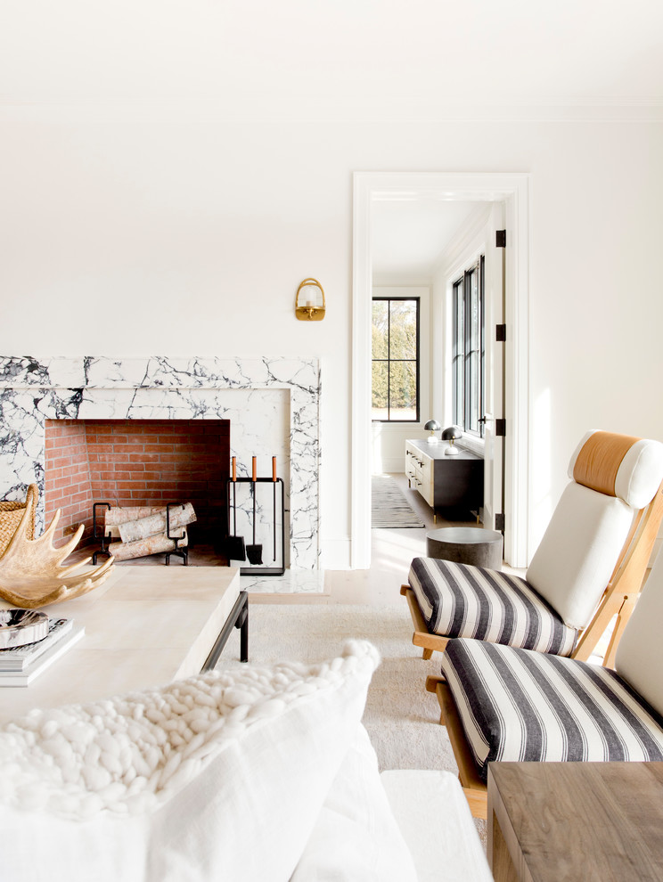Inredning av ett minimalistiskt stort separat vardagsrum, med ett finrum, vita väggar, ljust trägolv, en standard öppen spis, en spiselkrans i sten och beiget golv
