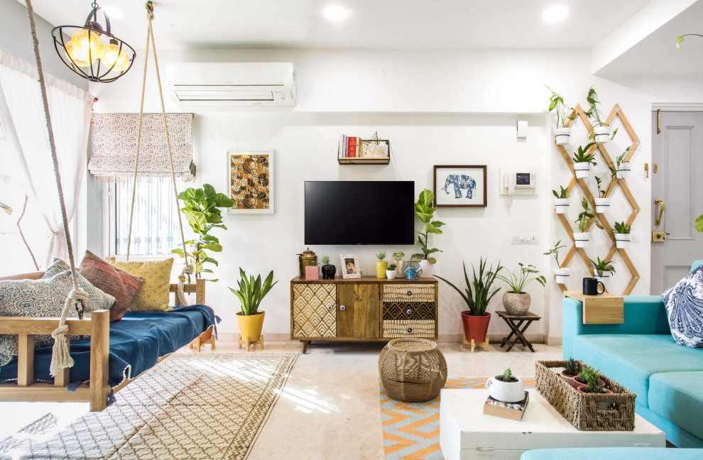 Esempio di un soggiorno boho chic aperto con pareti bianche, TV a parete e pavimento beige