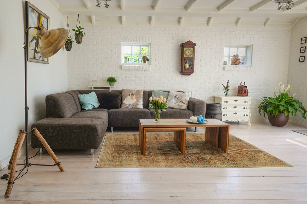 Photo of a medium sized farmhouse enclosed living room in Stockholm with white walls, painted wood flooring and white floors.