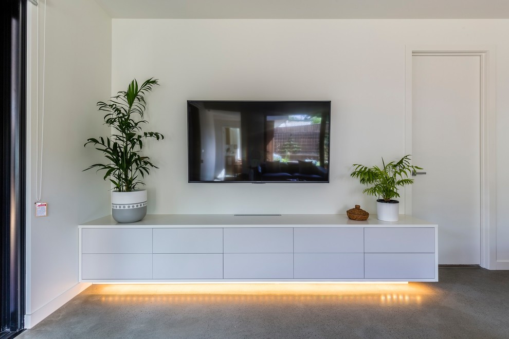 Photo of a small contemporary open plan living room in Melbourne with white walls, concrete flooring, no fireplace, a wall mounted tv and grey floors.