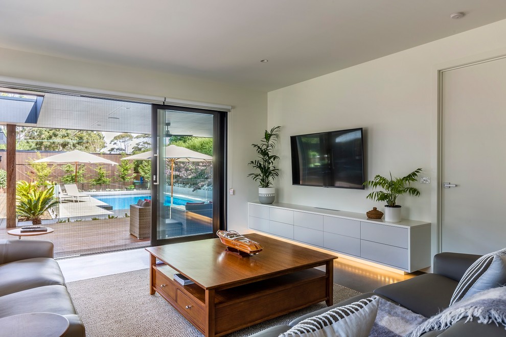 Inspiration for a small contemporary open plan living room in Melbourne with white walls, concrete flooring, no fireplace, a wall mounted tv and grey floors.