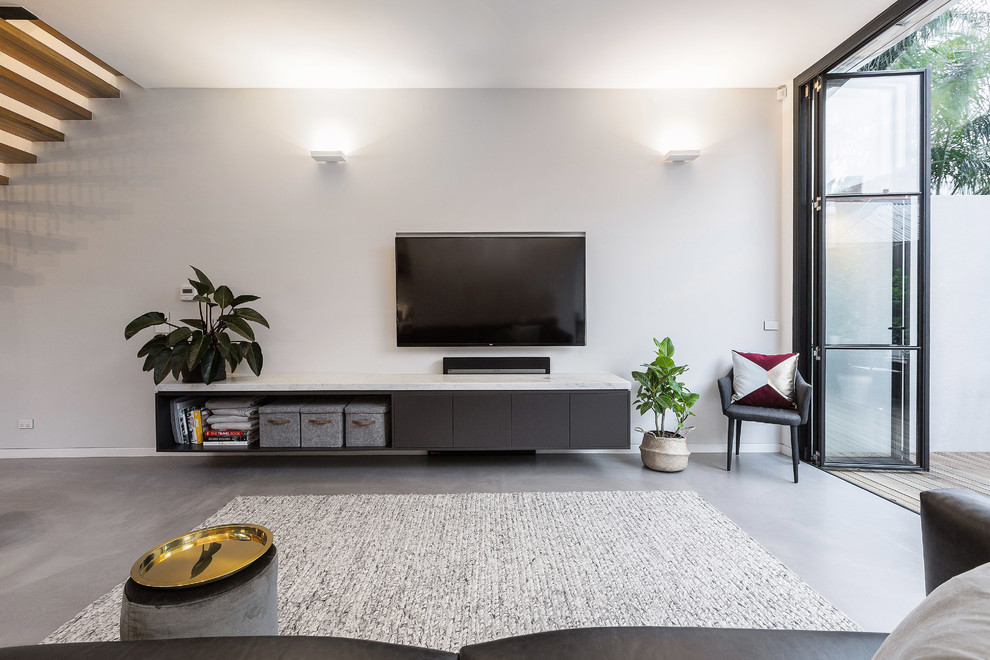 Photo of a medium sized contemporary open plan living room in Melbourne with grey walls, concrete flooring, a wall mounted tv and grey floors.