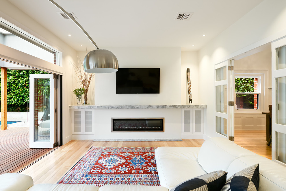 Großes, Offenes Modernes Wohnzimmer mit weißer Wandfarbe, hellem Holzboden und TV-Wand in Melbourne