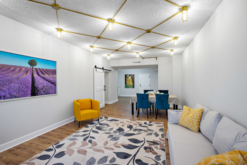 Imagen de salón abierto clásico grande sin chimenea con paredes beige, suelo laminado y suelo marrón