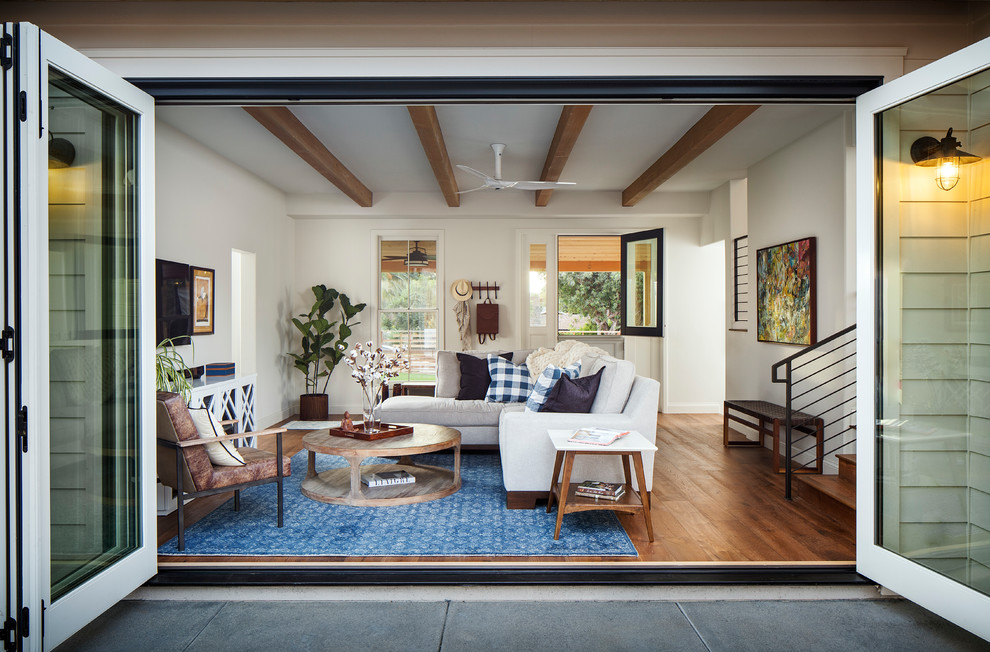 Esempio di un soggiorno classico con pareti bianche, pavimento in legno massello medio, TV a parete e pavimento marrone