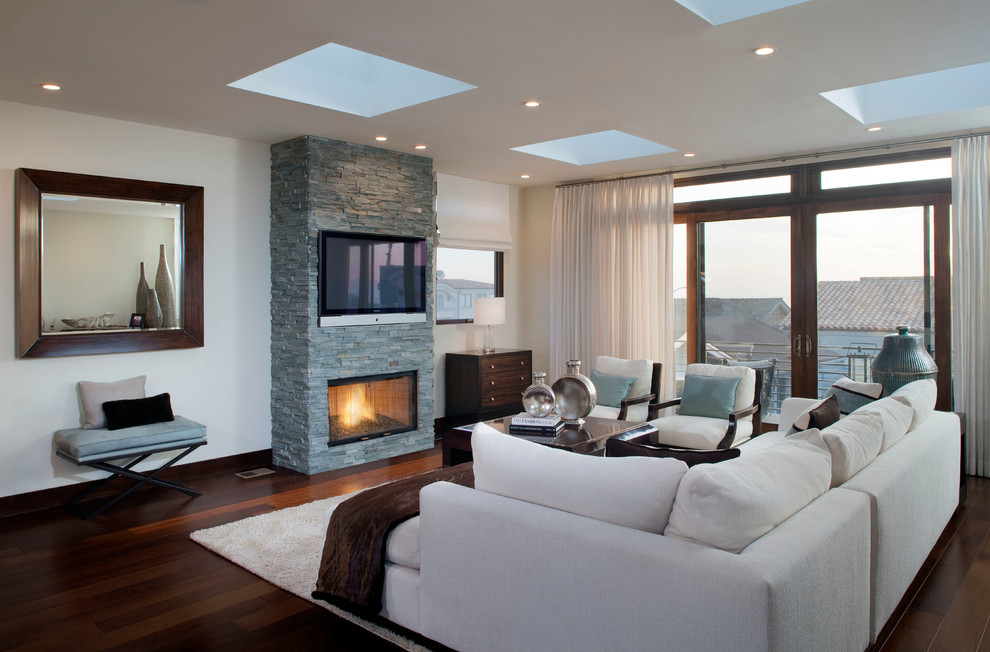 Medium sized contemporary formal open plan living room in Los Angeles with white walls, dark hardwood flooring, a standard fireplace, a stone fireplace surround and a wall mounted tv.