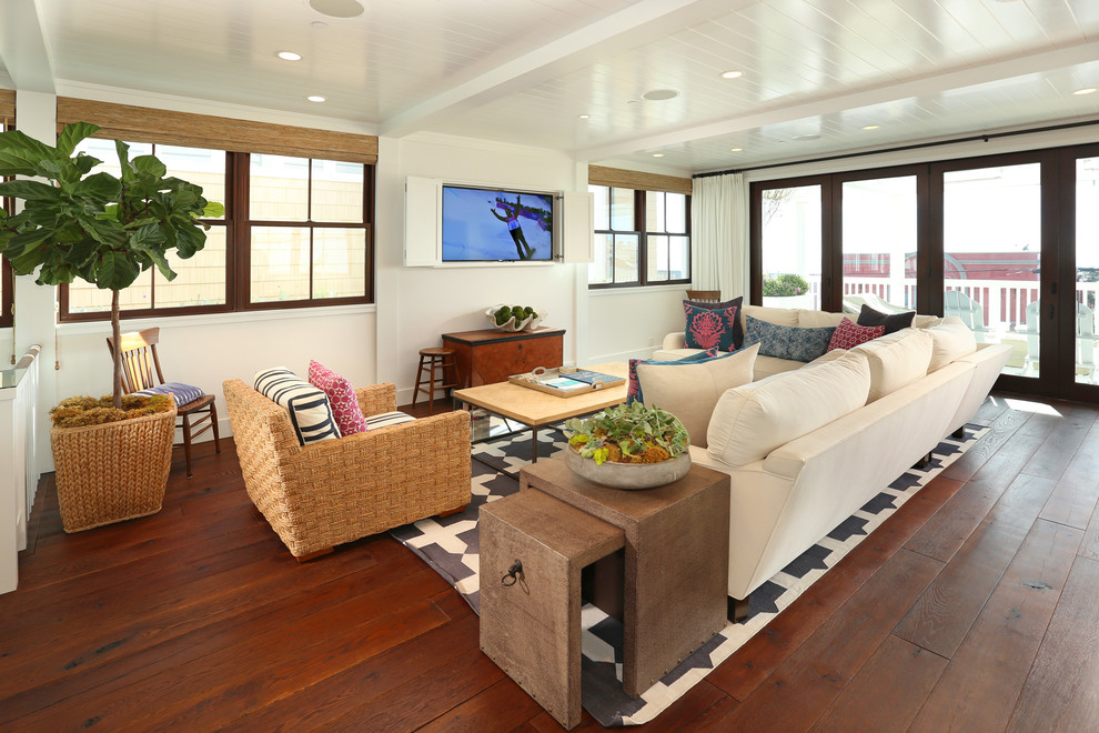 This is an example of a large beach style formal open plan living room in Los Angeles with white walls, dark hardwood flooring, a concealed tv and no fireplace.