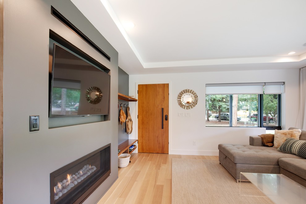 Exemple d'un grand salon moderne ouvert avec une salle de réception, un mur blanc, parquet clair, une cheminée standard, un manteau de cheminée en métal, un téléviseur encastré et un sol marron.