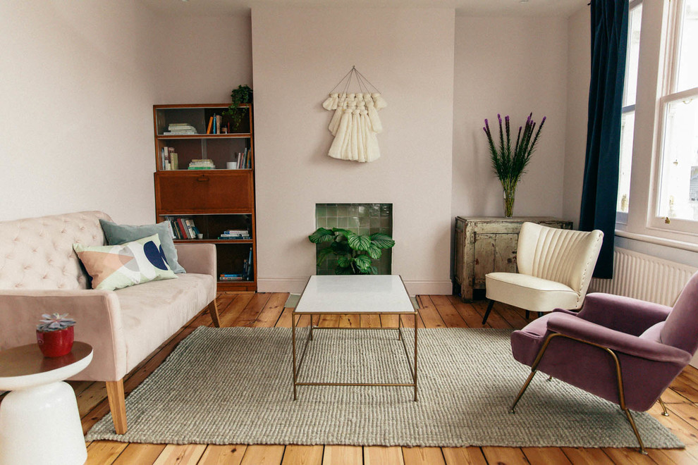 Idee per un soggiorno minimalista con pareti rosa e cornice del camino piastrellata