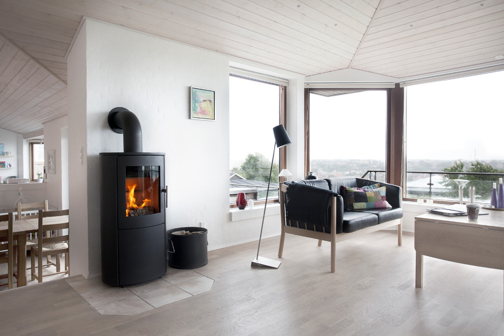 Skandinavisches Wohnzimmer mit dunklem Holzboden, Kaminofen und verputzter Kaminumrandung in Essex