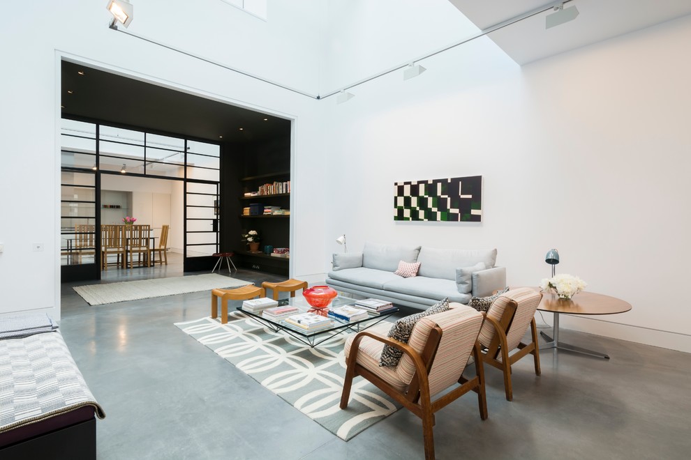 This is an example of an expansive urban formal open plan living room in London with white walls and concrete flooring.
