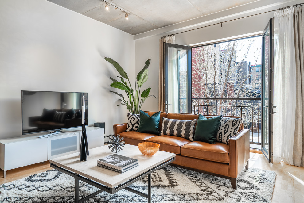 Example of a mid-sized urban open concept light wood floor and brown floor living room design in Minneapolis with white walls, no fireplace and a tv stand