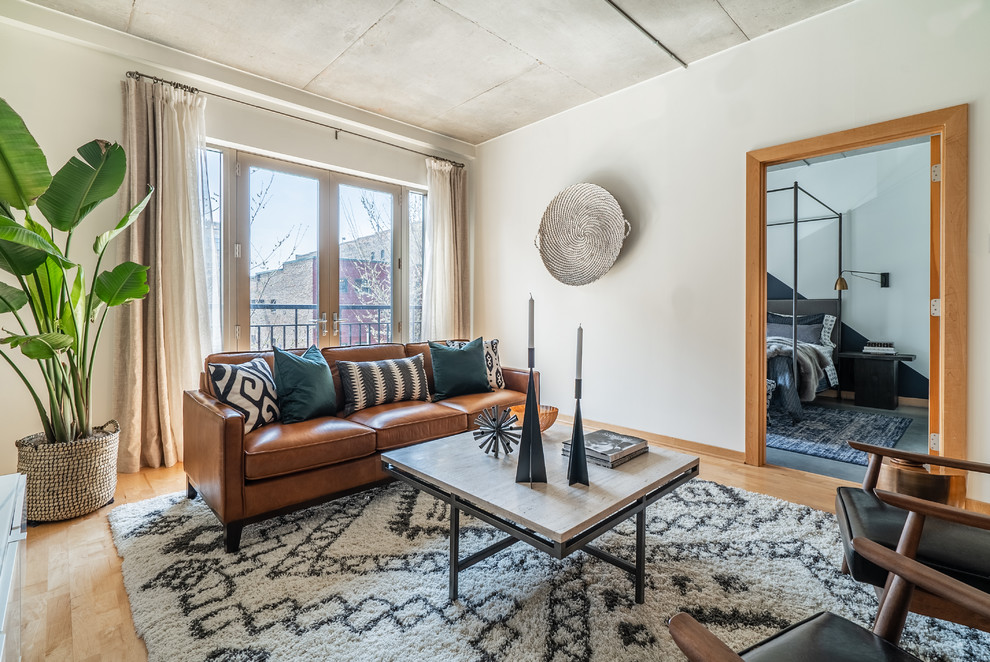 Example of a mid-sized urban open concept light wood floor and brown floor living room design in Minneapolis with white walls, no fireplace and a tv stand