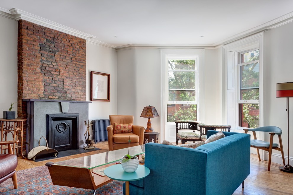 Mittelgroßes, Offenes, Fernseherloses Klassisches Wohnzimmer mit weißer Wandfarbe, braunem Holzboden, Kamin und Kaminumrandung aus Stein in New York