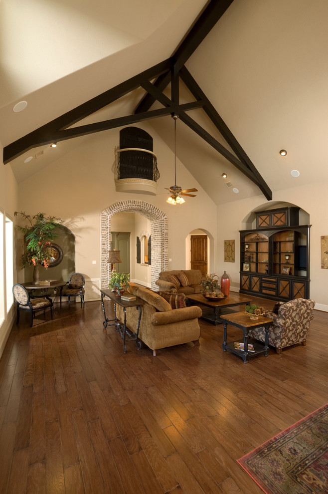 Пример оригинального дизайна: большая парадная, открытая гостиная комната в классическом стиле с бежевыми стенами, паркетным полом среднего тона, стандартным камином, фасадом камина из камня и коричневым полом без телевизора