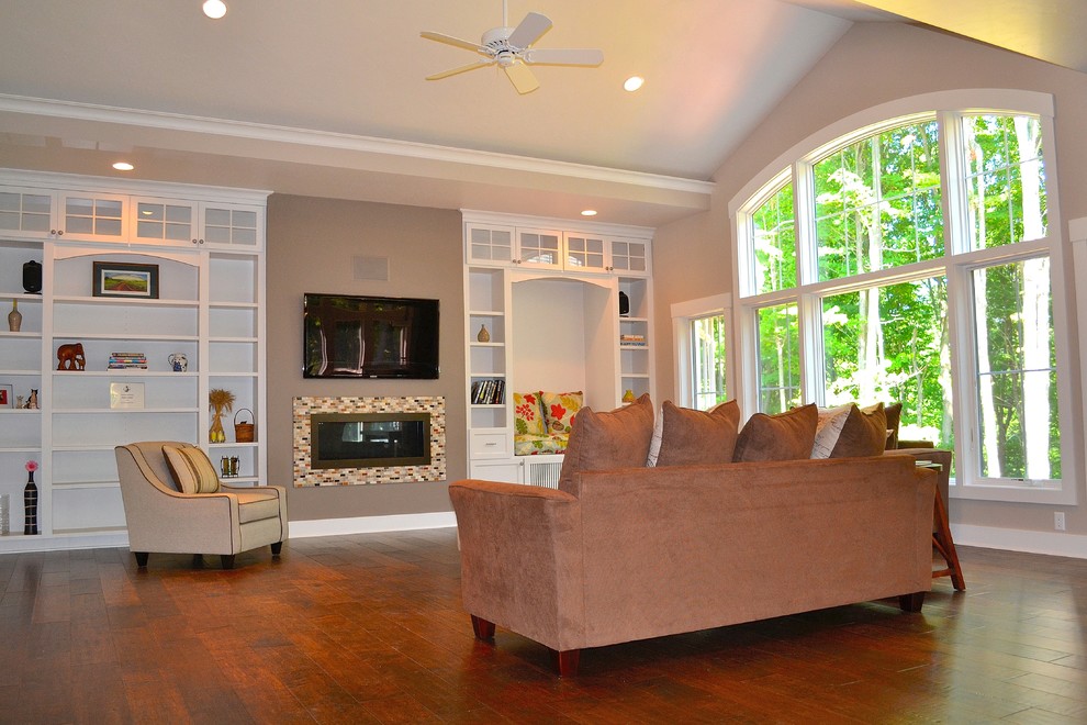 Photo of a large traditional open plan living room in Milwaukee with beige walls, a standard fireplace, a tiled fireplace surround and a wall mounted tv.